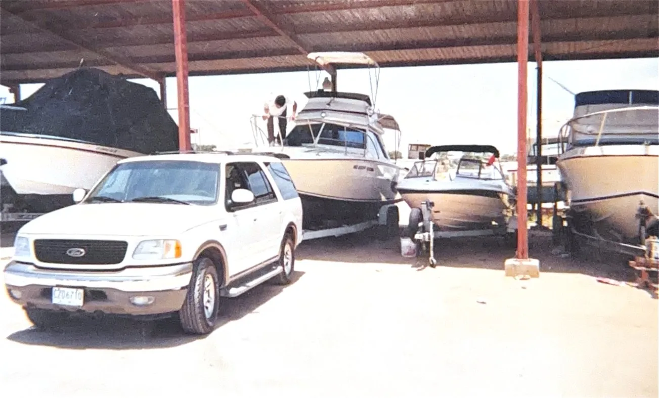 Boats on trailers under the roof of the dry storage yard, a truck parked alongside