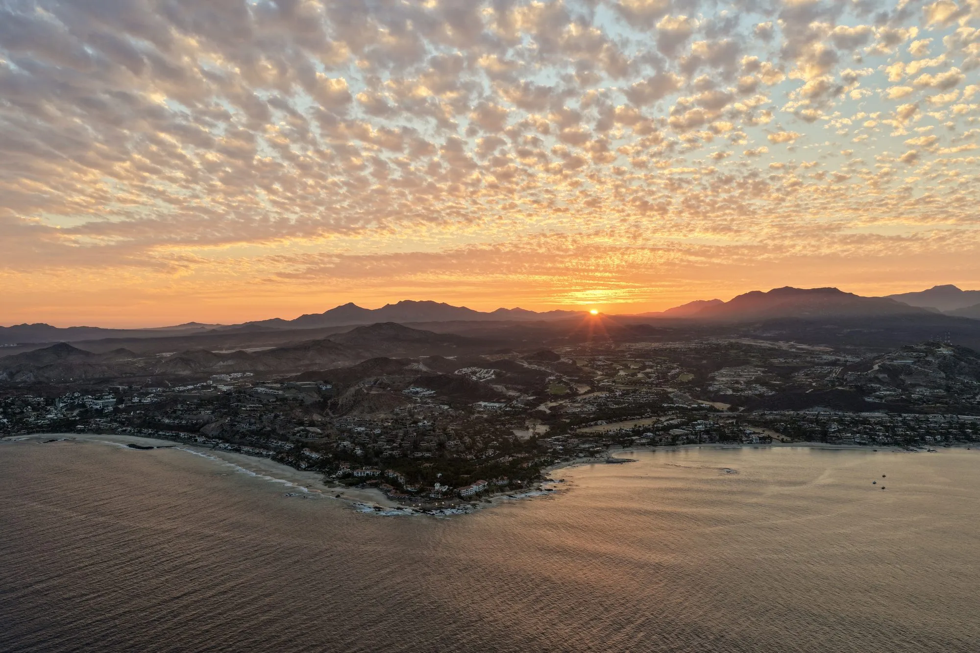 A yacht cruising the Los Cabos corridor at sunset