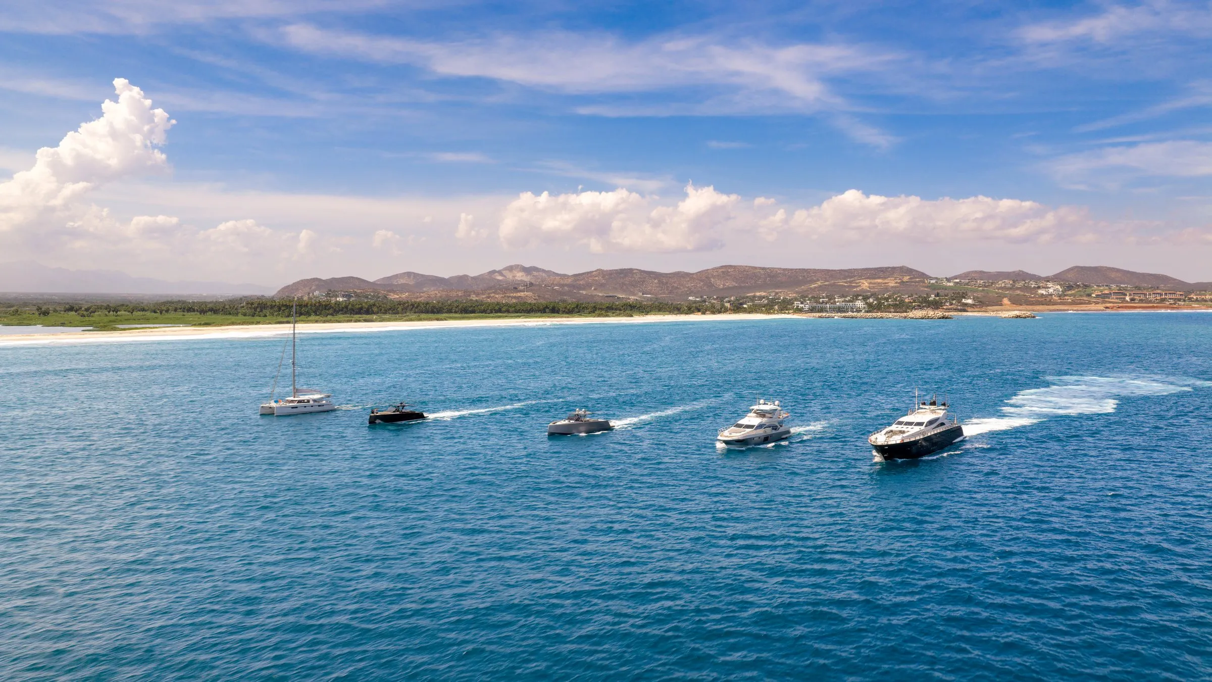 The Otaduy Yachts fleet under way together along the Los Cabos coastline, aerial view