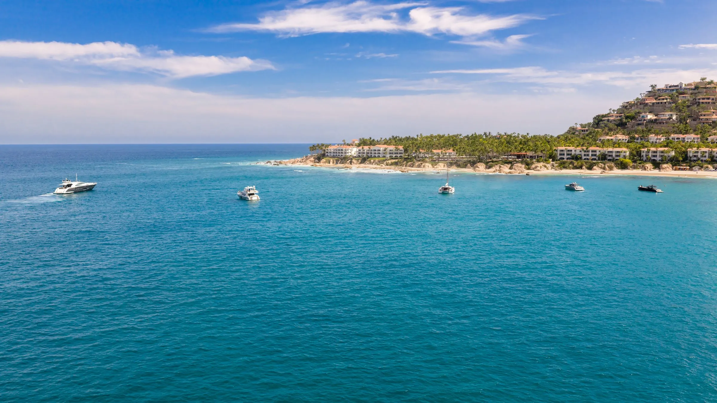Yachts of the Otaduy fleet at anchor off the beach at Palmilla, aerial view