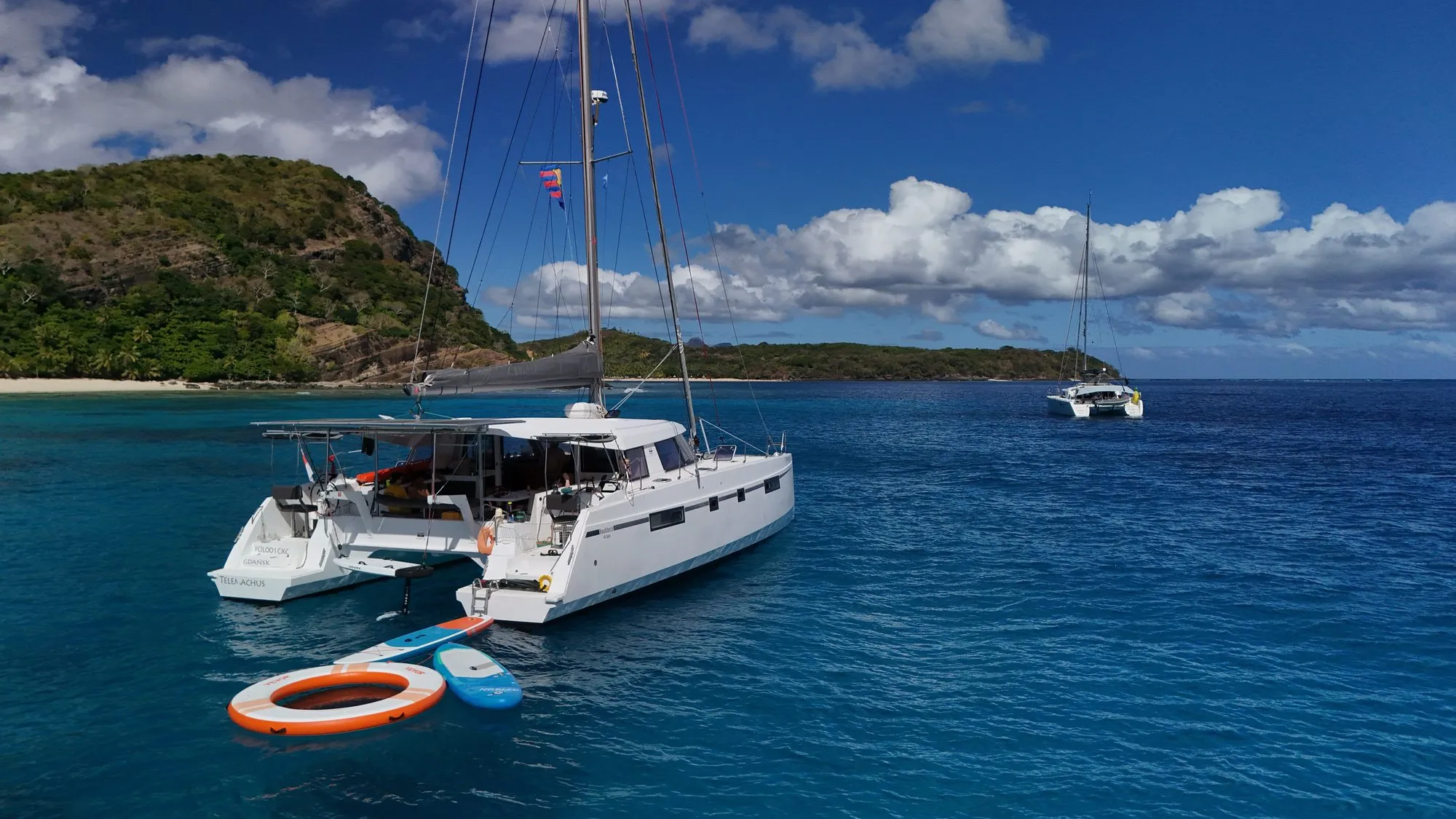 Telemachus at anchor with paddleboards and water toys, aerial view