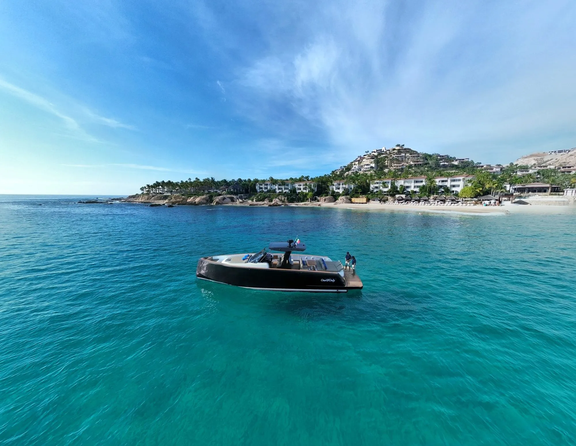 Bésame anchored in turquoise water off Palmilla beach, aerial view