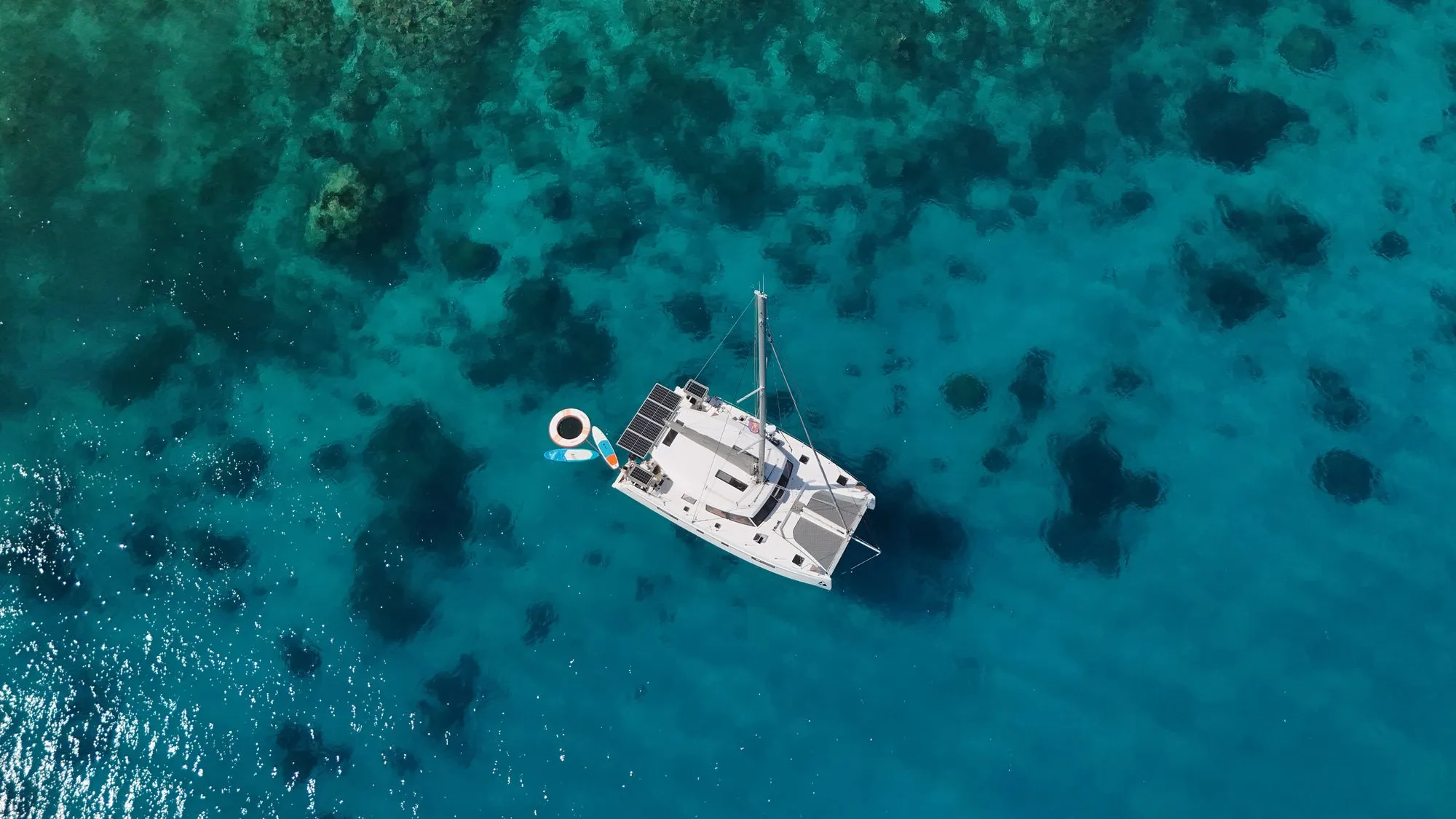 Top down aerial of Telemachus anchored in clear turquoise water