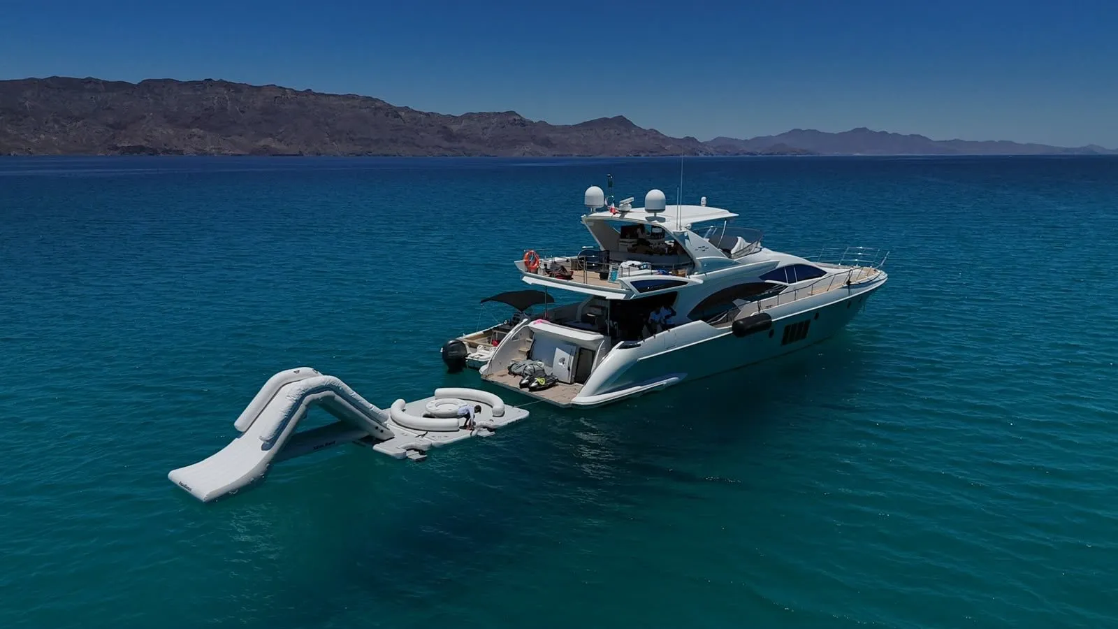 Aerial view of Cardinale at anchor with waterslide and floating lounge deployed