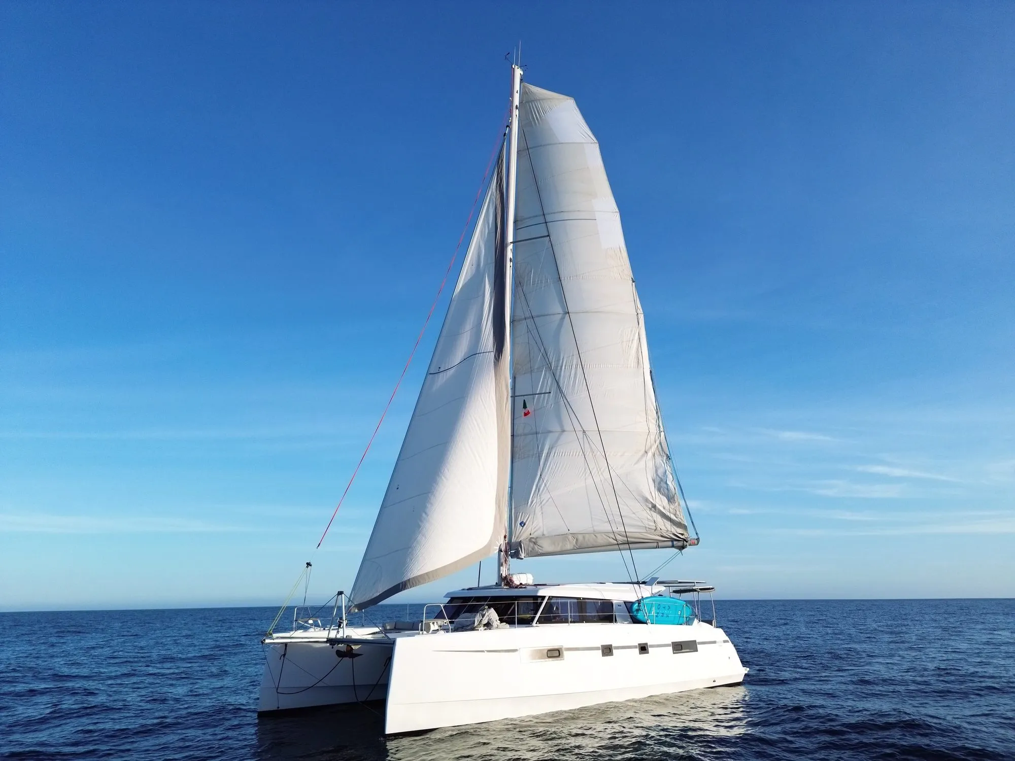 Telemachus sailing under full main and genoa on open water