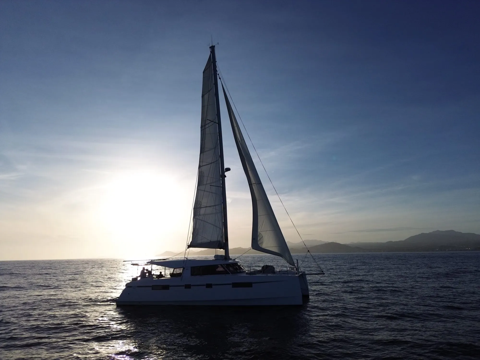 Silhouette of Telemachus under sail against the setting sun