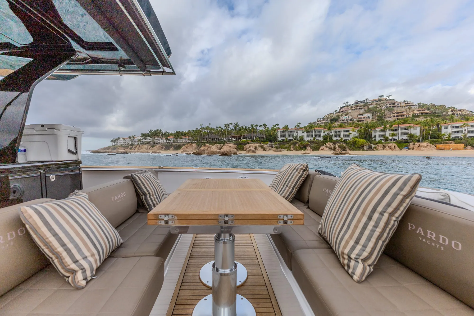 Bésame cockpit dining area with upholstered seating and coastal view