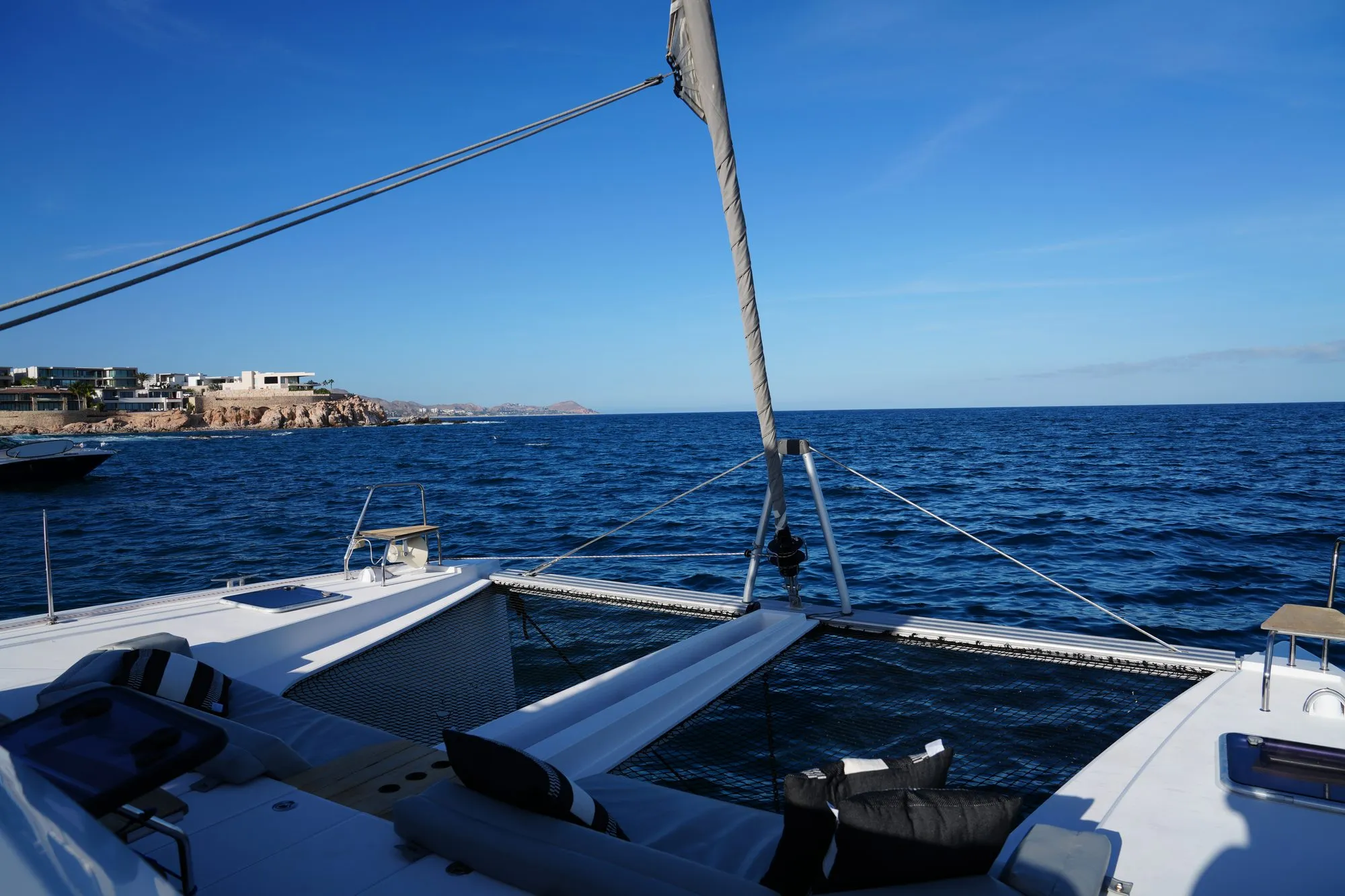 Bow trampolines of Telemachus with lounge cushions and coastline view