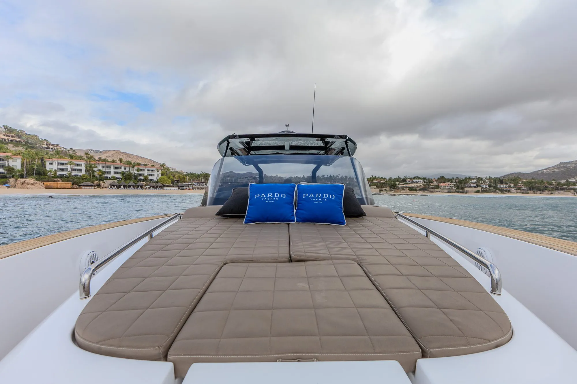 Bésame bow sunpads with Pardo Yachts pillows facing the beach