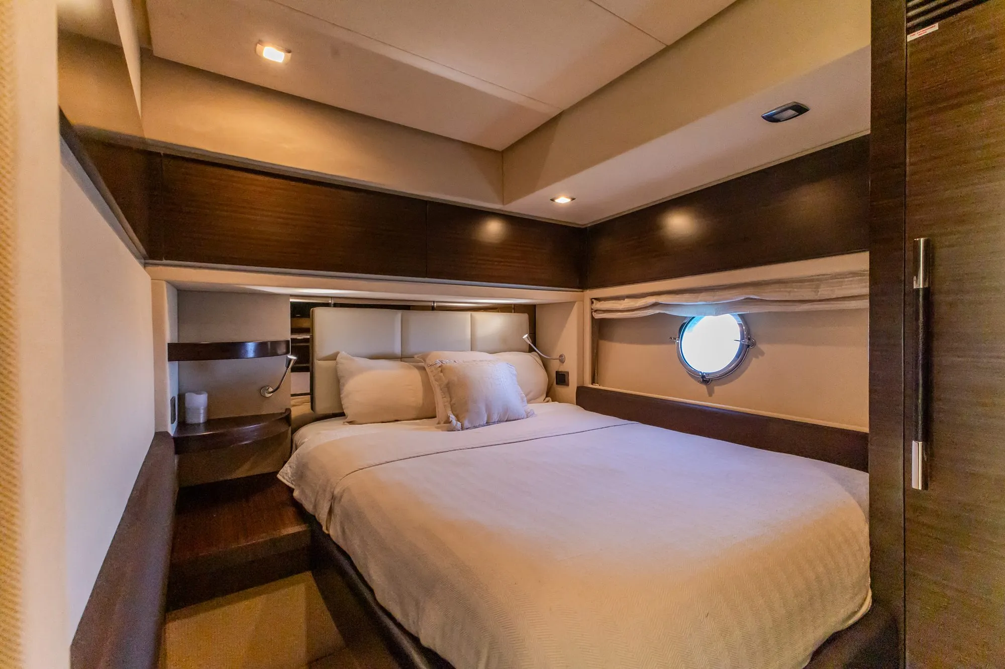 Guest cabin aboard Cardinale with double bed, walnut joinery and porthole