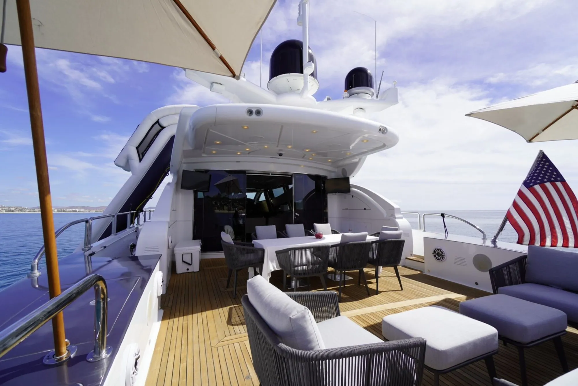 Aft deck dining table on GO set with white linen and teak underfoot