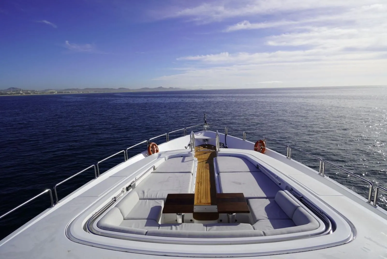 Bow lounge of GO with wraparound seating and sunpads facing the horizon