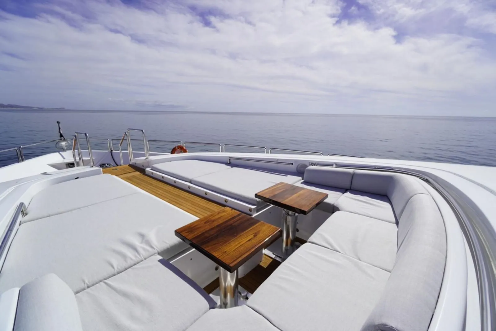 Sunpads and teak cocktail tables on the bow of GO