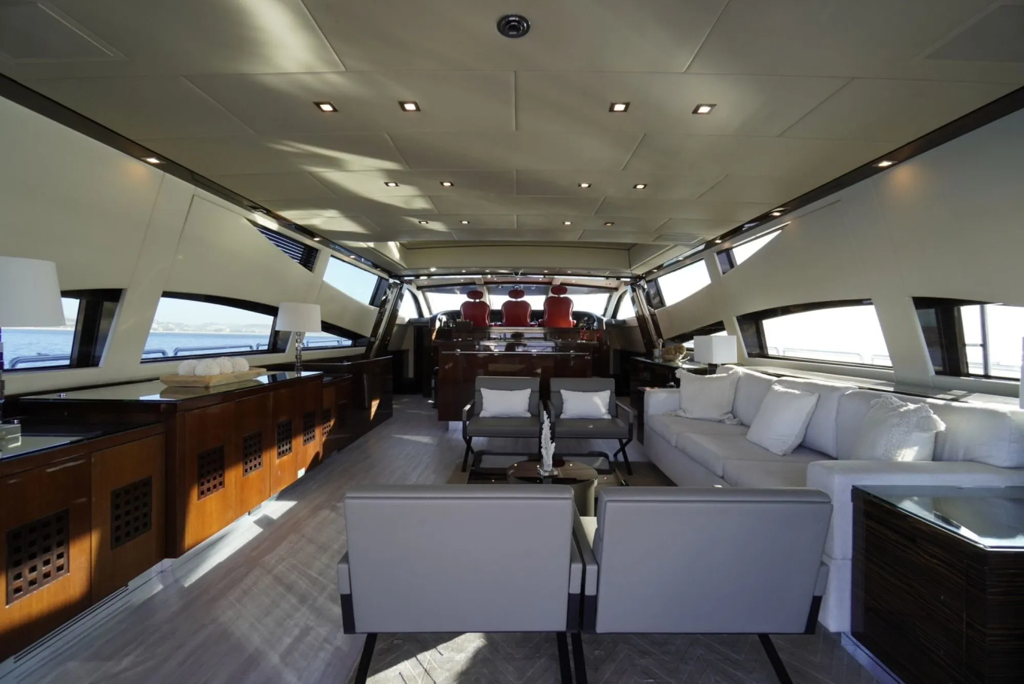 Main salon of GO with white sofas, lounge chairs and the helm forward