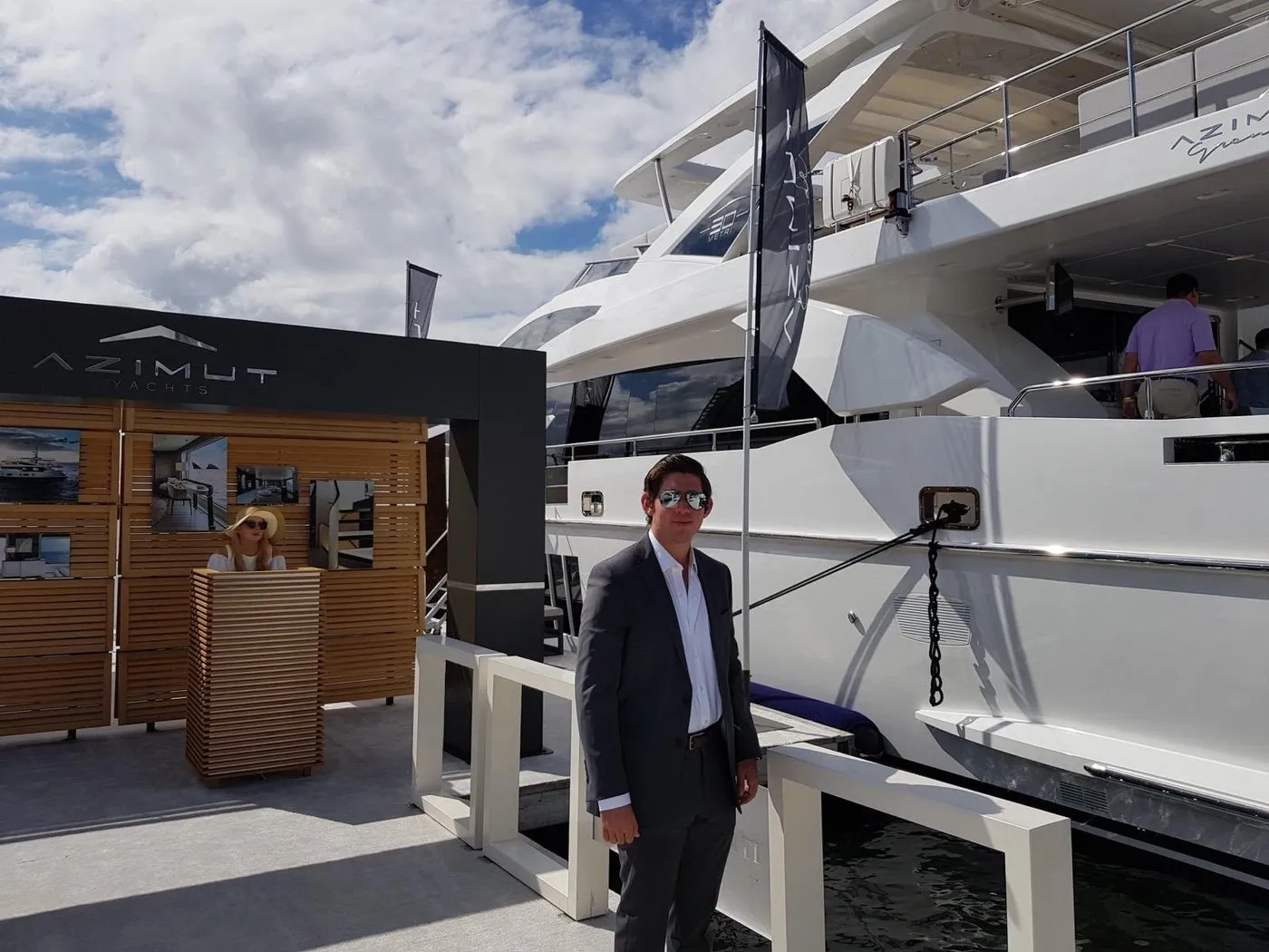 Gus Otaduy at nineteen on the docks at a boat show, beside a new Azimut motor yacht