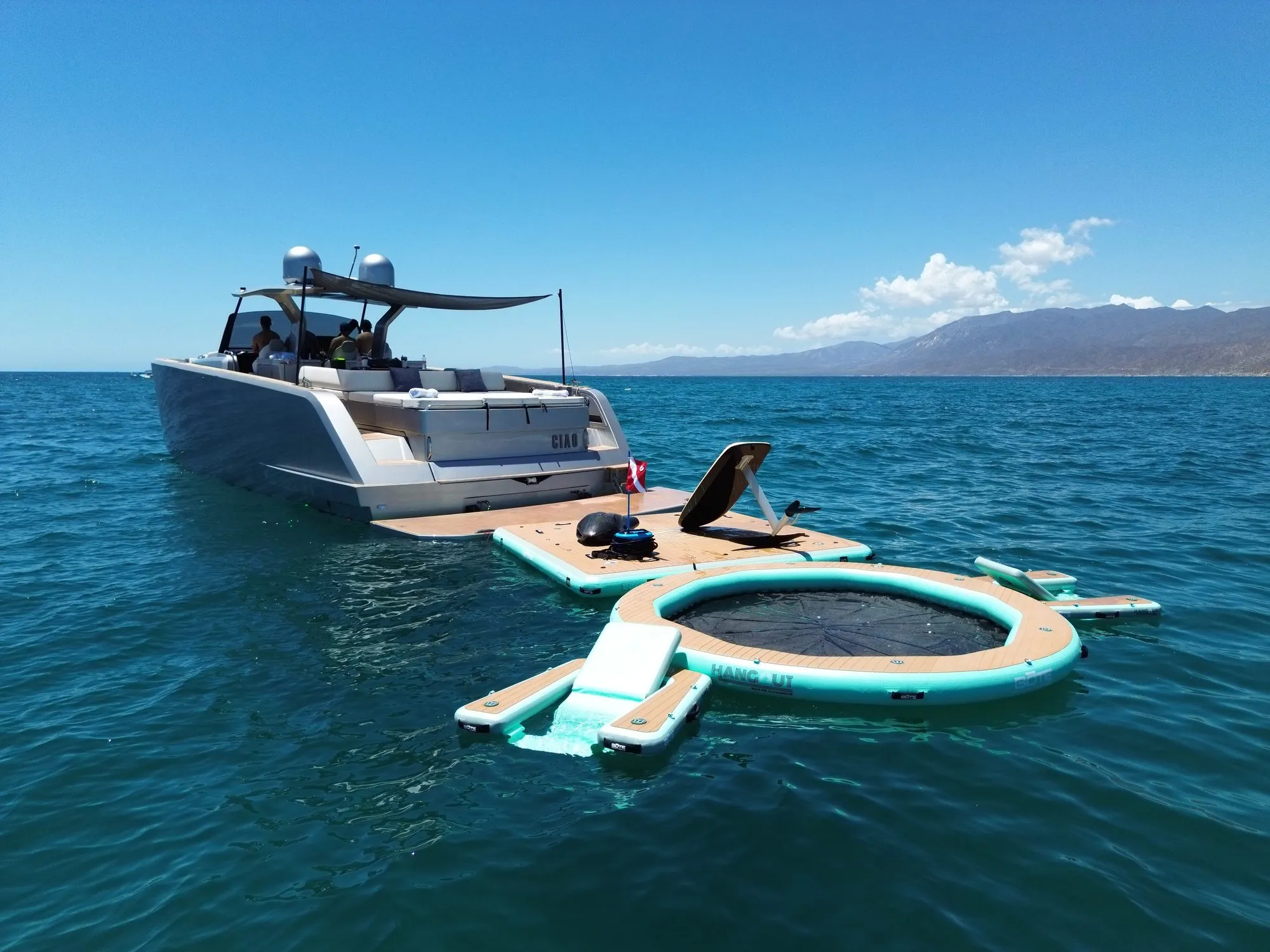 Aerial view of BOTE floating platforms and water toys behind an anchored yacht