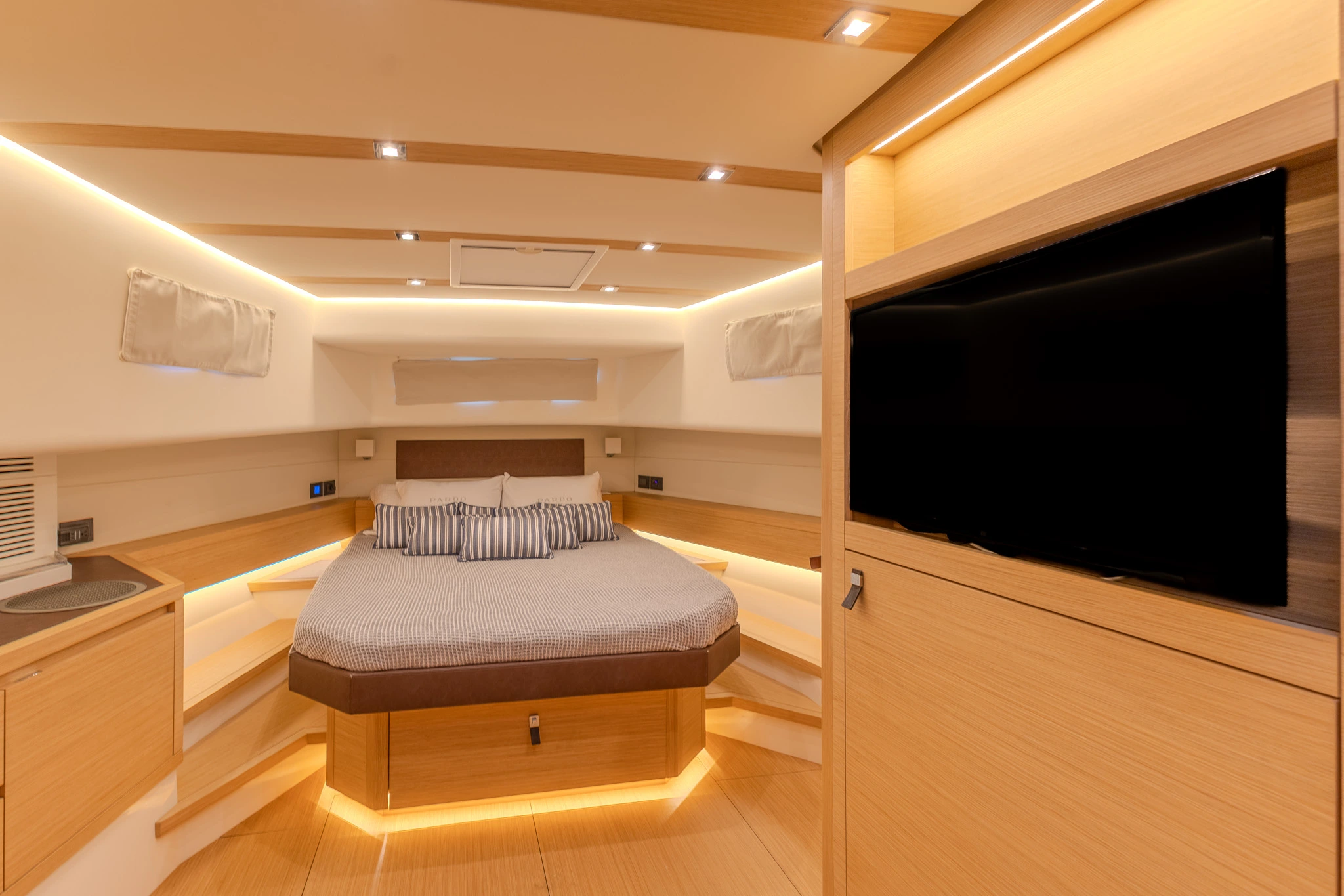 CIAO Yacht cabin with low lighting and new bedspread.