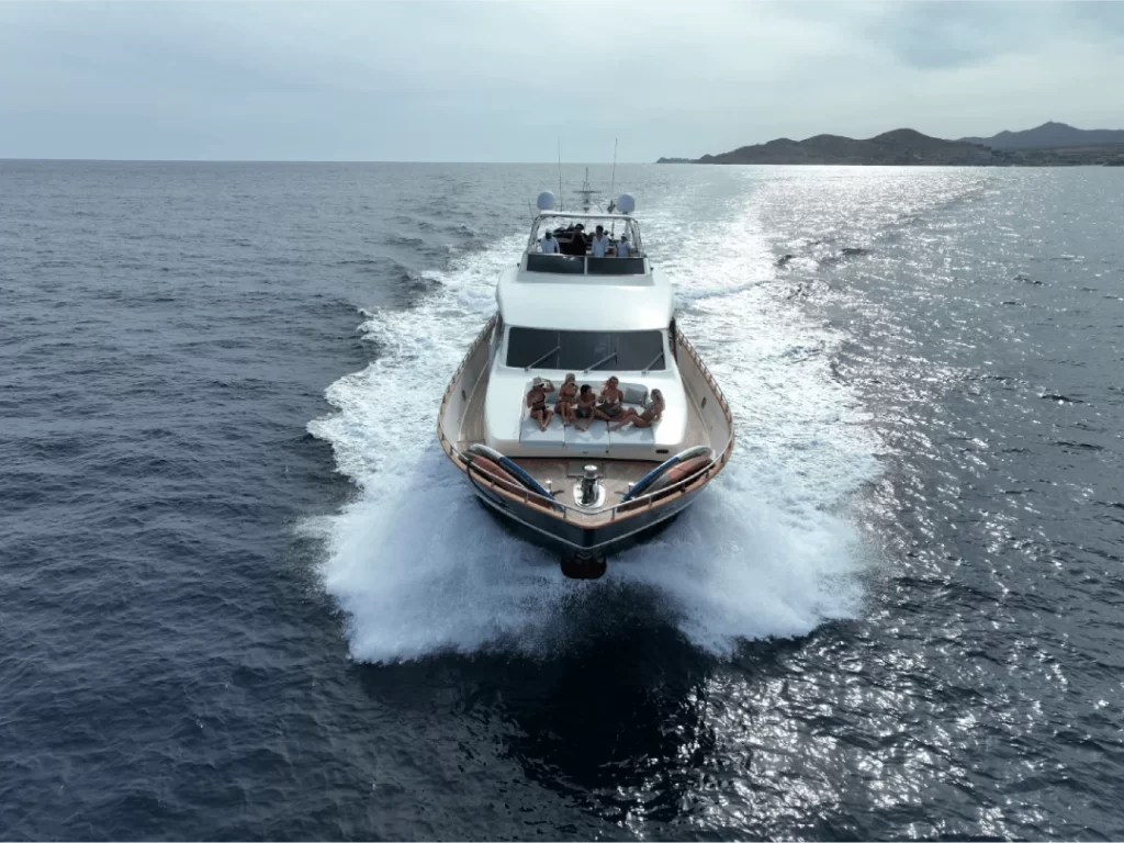 Otaduy's Catari yacht available for charter speeding through the sea with guests sat on the bow.