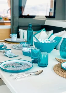 Blue Marine Business tableware is neatly laid on a white yacht table inside a yacht.