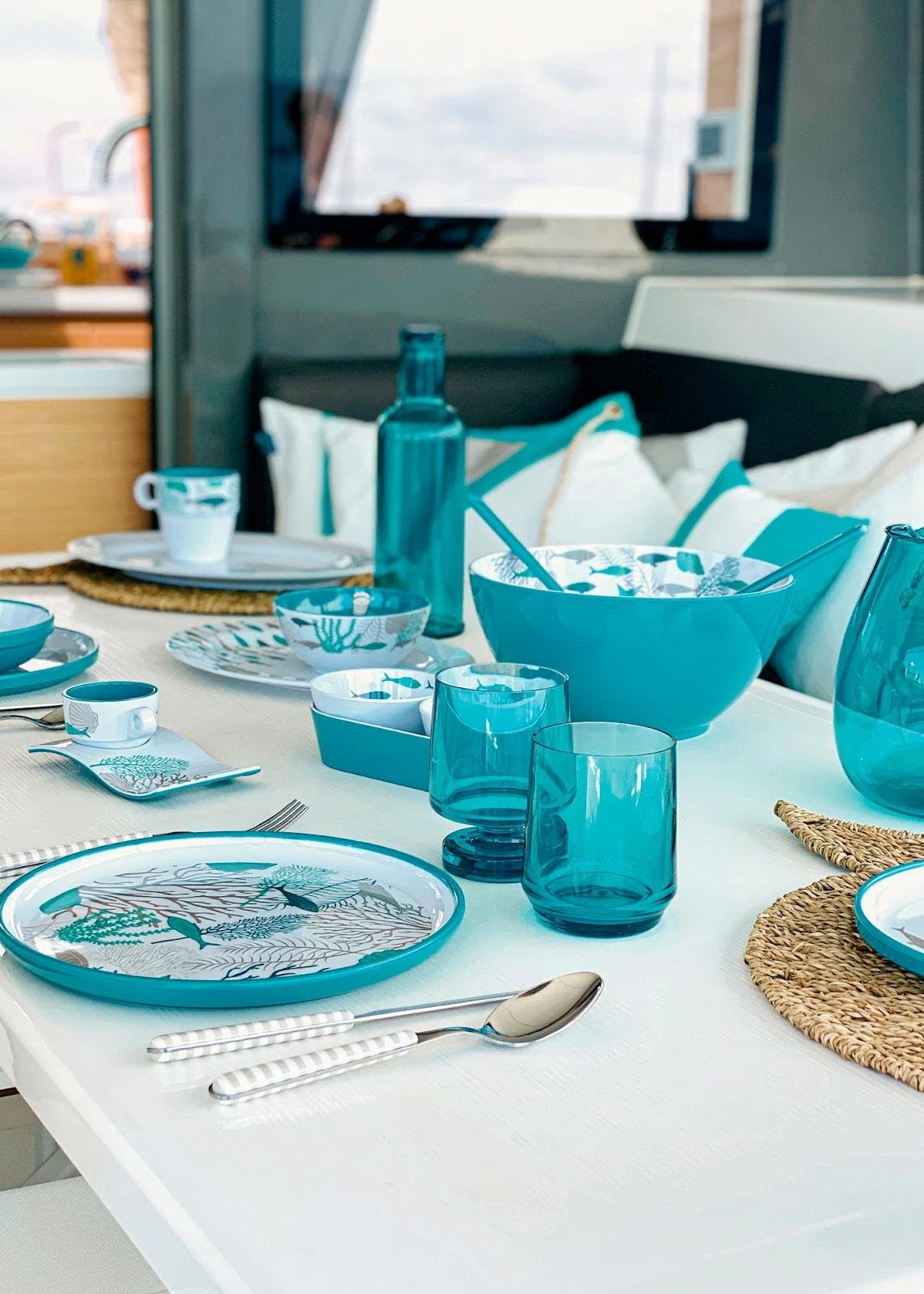 Blue Marine Business tableware is neatly laid on a white yacht table inside a yacht.