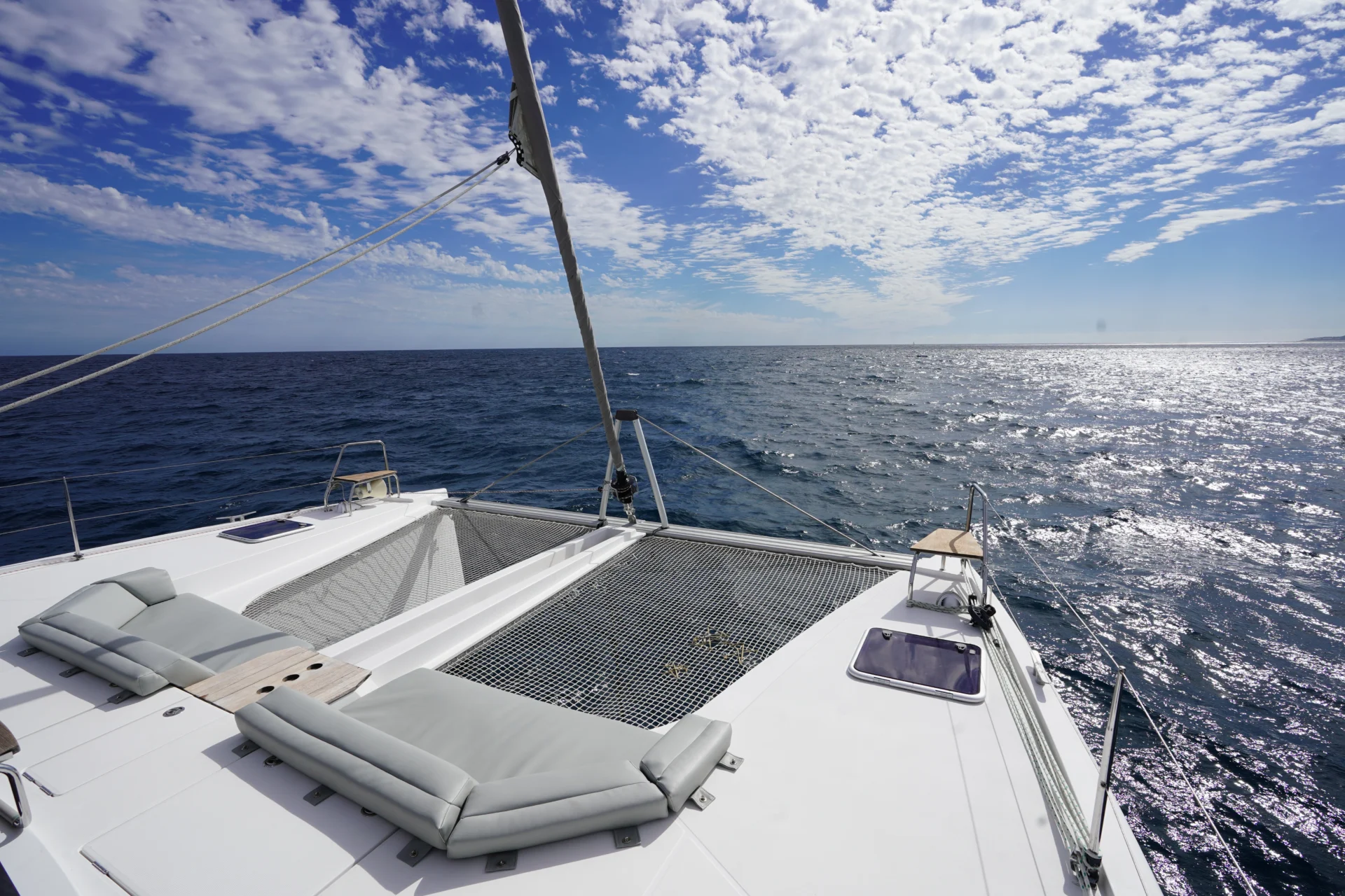 The exterior deck of Otaduy's charter catamaran Telemachus with two grey seating cushions.